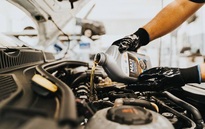 Óleo sendo abastecido em motor diesel na troca